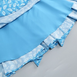 Detail view of double-layered blue floral skirt with daisy and polka dot prints