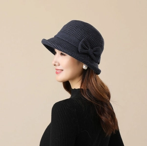 Detail showing the side bow and houndstooth pattern on a blue wool bucket hat
