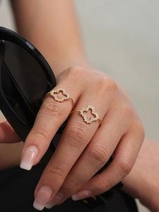 Bague trèfle à quatre feuilles dorée avec zircons brillants sur le doigt d'un mannequin