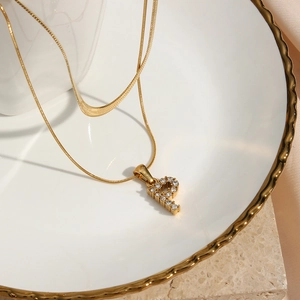 Close-up of gold double-layer necklace with a zircon-inlaid letter P pendant