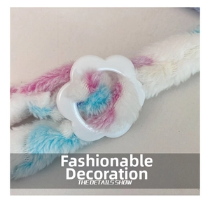 Close-up of soft tie-dye plush fabric with a white flower-shaped buckle detail