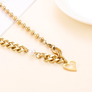 Détail du collier chaîne à billes et gourmette dorée avec perle et pendentif cœur