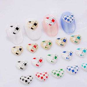 Detailed view of heart-shaped checkerboard nail charms with crystal inlay on tips