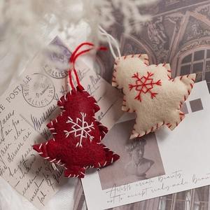 Handmade wool felt Christmas tree ornaments with snow embroidery on vintage backdrop