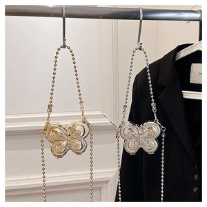 Detailed view of butterfly-shaped mini metal crossbody bags in gold and silver finish