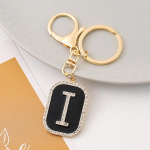 Detailed close-up of golden letter I keychain pendant with black base and rhinestones
