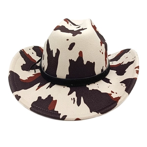 Detail of western cowboy hat with cow print pattern and black leather band decoration