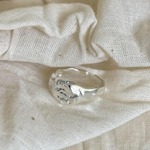 Detail of minimalist 925 silver irregular open ring with lava texture on linen fabric
