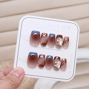 Detail of gradient press-on nails with glitter accents and large emerald-cut rhinestones