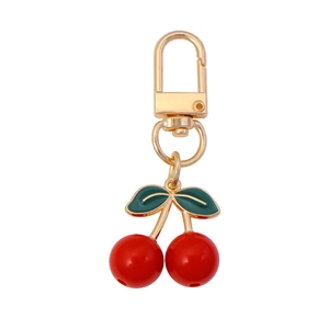 Cute cherry pendant keychain with red beads and green leaf on golden metal clasp