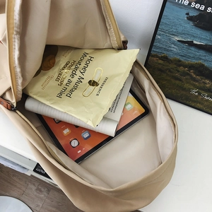 Beige large capacity backpack showing internal storage for tablet books and snacks