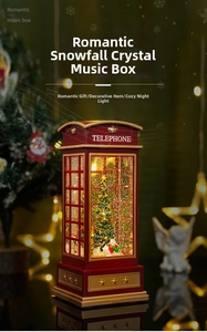 Macro view of red telephone booth music box with snow effect and internal Christmas tree