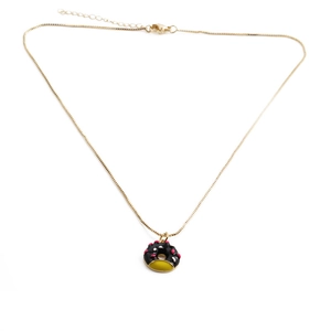 Détail du collier plaqué or avec pendentif donut noir et vermicelles roses