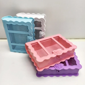 Detail of book-shaped plastic jewelry boxes with rose relief and transparent window