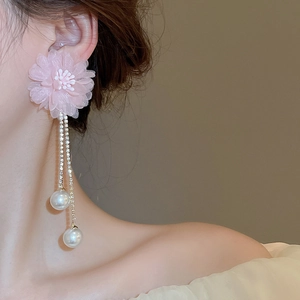 Detailed close-up of lace flower earrings with rhinestone tassels and white pearls