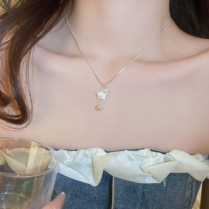 Detail of silver beaded necklace with star pendant and pearl on model's neckline