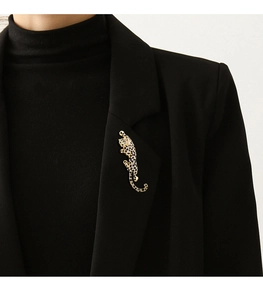 Detail of a leopard brooch with sparkling stones on a black suit lapel for a premium look