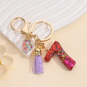 Detail of red glitter number 7 resin charm with purple tassel and gold keychain