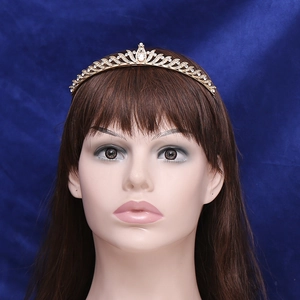 Elegant gold princess tiara with clear zircons shown on a model against blue background