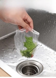 Close-up of fine mesh kitchen sink filter bag holding food waste over a stainless sink