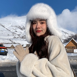 Close-up of white plush trapper hat and knitted mittens for winter outdoor protection
