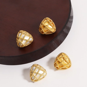 Macro view of woven mesh 18K gold plated triangular stud earrings with vintage texture