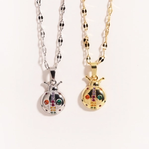 Close-up of gold and silver ladybug necklaces with rainbow zircon stones