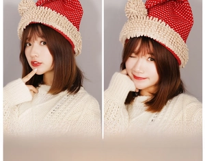 Detail of red polka dot Christmas hat featuring plush sherpa fleece brim on a model