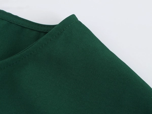 Dettaglio del tessuto dell'abito verde scuro con cuciture di alta qualità e consistenza