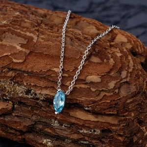 S925 sterling silver necklace with marquise sea blue zircon pendant on bark background