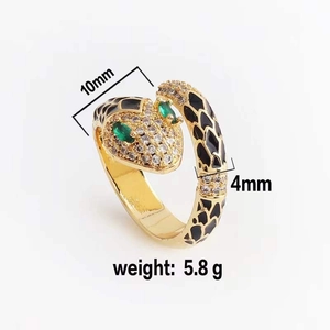 Detailed view of gold snake ring with black enamel scales and green zircon eyes