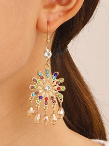 Detail of bohemian floral drop earring with colorful rhinestones on model's ear