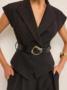 Combinaison noire sans manches avec ceinture à boucle dorée pour un look professionnel chic