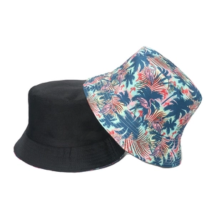 Close-up of a black cotton bucket hat paired with a tropical flamingo and palm print design