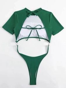Detail of emerald green cutout swimsuit with bow tie neck and metallic ring accents