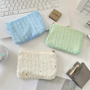 Detailed view of three sequined chiffon flower coin purses in blue, green and beige colors
