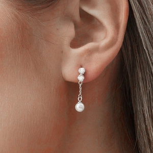 Close-up of S925 silver asymmetric pearl tassel earrings worn on ear for style