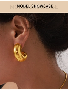 Close-up of luxury 18K gold plated teardrop earrings on a model showing smooth metallic finish