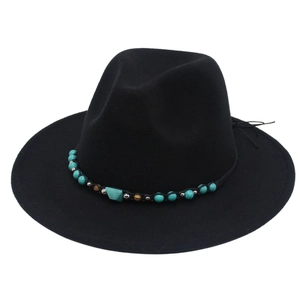 Detailed shot of ethnic style turquoise beads and stones on black wool felt fedora hat