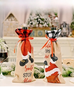 Detail of burlap Christmas wine bottle bags with plaid patterns and Santa Stop Here print