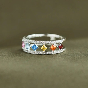 Macro-opname van zilveren ring met dubbele rij diamanten en kleurrijke ruitvormige stenen