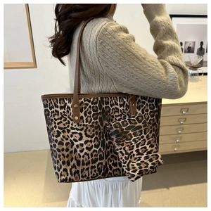 Close-up of leopard print tote bag with matching coin purse worn on model shoulder