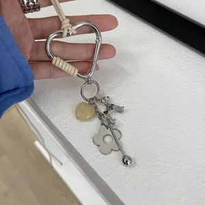 Détail du collier en corde de coton avec mousqueton cœur argenté et breloques chiot