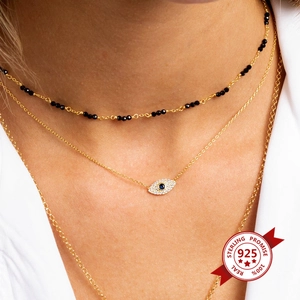 Three-layer gold s925 silver necklace set featuring blue evil eye crystal pendant on model