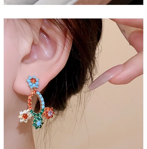 Close-up of elegant flower earrings with multi-colored zircons on a model