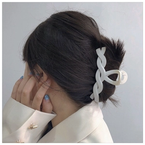 Detail of white braided twist hair claw clip styled on woman's elegant updo