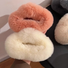 Detailed close-up of soft coral pink and cream faux fur plush hair clips texture