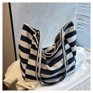 Detailed close-up of striped canvas tote bag showing navy and beige fabric texture