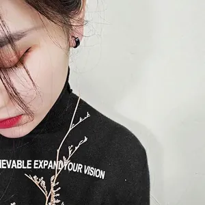 Minimalist black stainless steel hoop earring for men and women on a fashion model