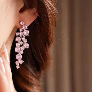 Elegant silver tassel earrings with irregular pink zircon stones worn by a model